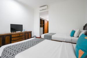Postel nebo postele na pokoji v ubytování Sans Vibes Puri Mango Hotel Sanur