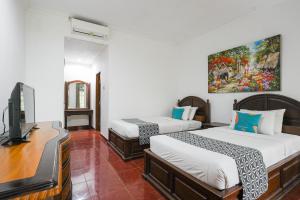 Postel nebo postele na pokoji v ubytování Sans Vibes Puri Mango Hotel Sanur