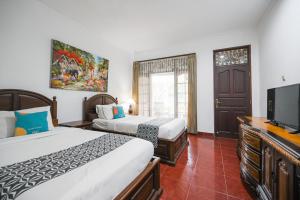 Postel nebo postele na pokoji v ubytování Sans Vibes Puri Mango Hotel Sanur