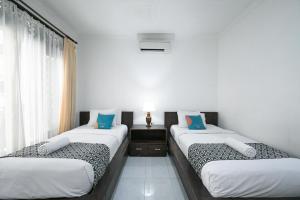 Postel nebo postele na pokoji v ubytování Sans Vibes Puri Mango Hotel Sanur