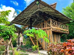 a bamboo house with a thatched roof at Sandybridge Eco Farm at Relly's Restaurant in Puerto Princesa City