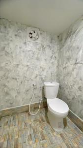 a bathroom with a white toilet in a room at The White House Pakbara in Ban Pak Ba Ra