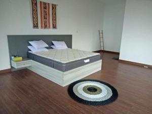 a bedroom with a bed and a rug on a wooden floor at Villa lofous in Pasirpogor +20 photos
