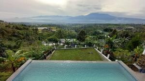 a swimming pool with a view of a mountain at Villa lofous in Pasirpogor