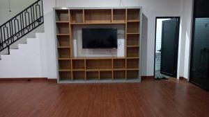 a living room with a tv and a staircase at Villa lofous in Pasirpogor