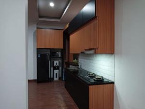 a kitchen with a stove and a black refrigerator at Villa lofous in Pasirpogor