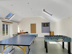 a room with two ping pong tables in it at The Barn at Rainsbury House Upton in Upton