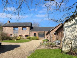 an exterior view of a house with a gravel driveway at The Barn at Rainsbury House Upton in Upton