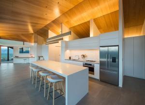 a kitchen with a large island with bar stools at Hawk House by Sotheby's Luxury Rental Homes in Queensberry