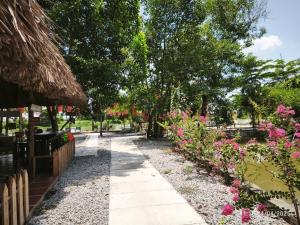 a garden with pink flowers and a pathway at Cắm trại trong ngày view sông - Homestay Mẹ Khang 2 in Cu Chi