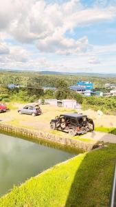 two cars parked in a parking lot next to a body of water at Conara Resort Lake View in Shillong +7 photos