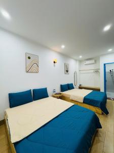 two beds in a room with blue and white at MON House 2 in Ấp Sung Xuân