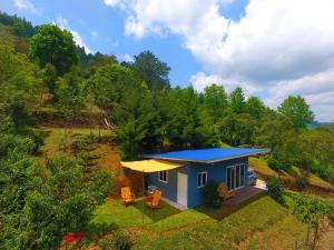 a small house with a blue roof in a field at Casa Torogoz in Santa Cruz Verapaz