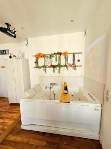 a white bath tub sitting in a room at Le 2005 Double BALNEO, Lit QUEEN SIZE, soirée romantique in Grenoble +28 photos