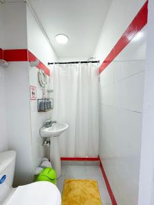 a bathroom with a white toilet and a sink at Casa Azul Mosaika in San Andrés
