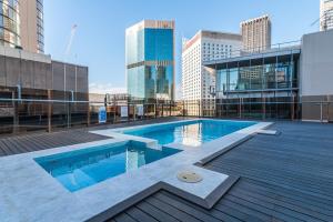 a swimming pool on top of a building with tall buildings at CLDN4- Studio in Central Sydney CBD with Pool in Sydney