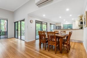 a kitchen and dining room with a table and chairs at Triple B - Beach Bush Birds in Dunbogan +9 photos