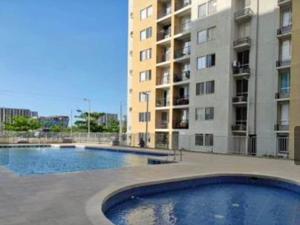 a large swimming pool in front of a building at Apartamento acogedor in Barranquilla