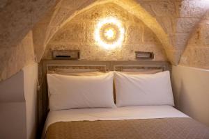 a bed with white pillows in a room at La Stella Del Pupo CATALDO in Fasano
