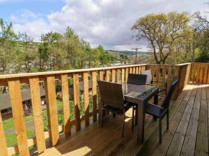 a wooden deck with a table and chairs on it at 3 Manleigh Park in Ilfracombe