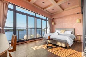 Un dormitorio con una cama grande y grandes ventanales. en 河海之間 Between River and Sea, en Wujie