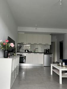 a large kitchen with white cabinets and a table at Blue Breeze Apart-Danai B in Ofrínion