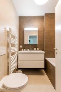 a bathroom with a toilet and a sink and a tub at Luxurious 2BR Family Apartment - Champel in Geneva +19 photos