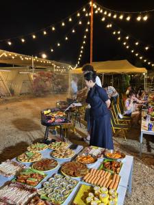 a woman standing in front of a table of food at SAY Camp Forest in Cần Giờ