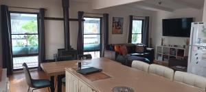 Una sala de estar con un sofá y una estufa. en Coves Cottage, en Piries