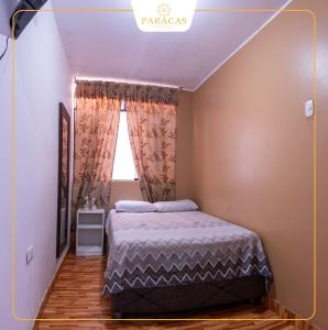a bedroom with a bed and a window at Hostal Paracas I in Ica +7 photos