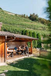 a group of people sitting at a picnic table in a vineyard at Hofer Hof in Feldthurns
