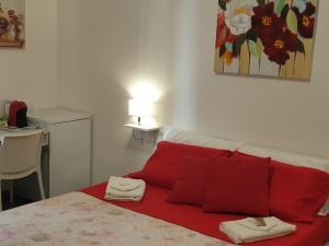 a bed with red pillows in a small room at Cartia Affittacamere in Ragusa +15 photos