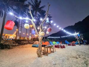 a tree with lights on the beach at night at Biệt Thự Villa Thảo Vy in Ly Son