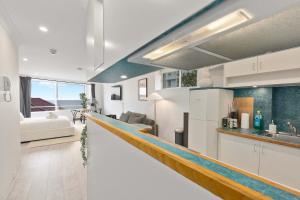 a kitchen and living room with a long counter top at Amazing Ocean View Studio at Bondi Beach in Sydney +28 photos