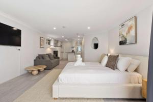 a white bedroom with a large bed and a couch at Iconic Bondi Beach Views in Sydney +19 photos
