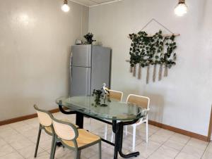 a dining room table with chairs and a refrigerator at Bintang Haven in Tawau