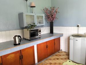 a kitchen counter with a microwave and a vase of flowers at Bintang Haven in Tawau