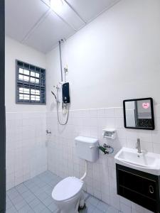 Un baño blanco con inodoro y lavabo. en Outdoor BBQ Air Putih 4R3B Homestay, en Kuantan