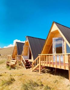 a row of wooden huts in a field at Taasir Yurt Camp in Dzhangyaryk