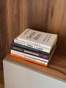 a stack of books sitting on top of a shelf at Apartman Green Divčigora in Divčibare +55 photos