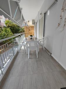 un patio avec une table et des chaises sur un balcon dans l'établissement Lidia Apartments Nea Peramos 1, à Néa Péramos