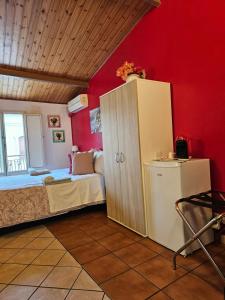 a bedroom with a bed and a cabinet and red walls at Oasi Iblea Now in Ragusa
