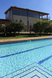 a large swimming pool with a building in the background at Solar do Alambique in Angeja