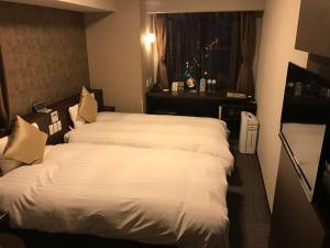 多美迎PREMIUM难波酒店客房内的一张或多张床位