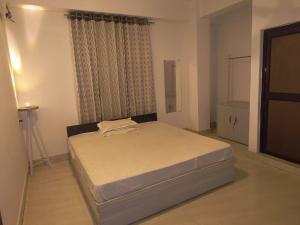 a bedroom with a bed in a room with a window at Rising Homestay in Guwahati