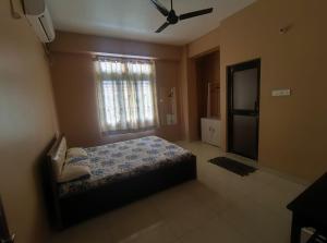 a bedroom with a bed and a window and a bathroom at Rising Homestay in Guwahati