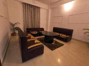 a living room with two couches and a table at Rising Homestay in Guwahati