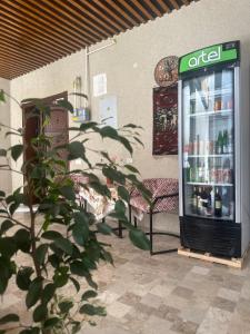 an open refrigerator with drinks in it next to a chair at Abuzar in Bukhara