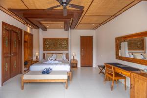 a bedroom with a bed and a desk at Micaela Bali Ubud Villas in Tegalalang