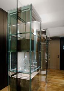 a glass display case with glasses on a wooden floor at Andaz 5th Avenue, By Hyatt in New York +110 photos